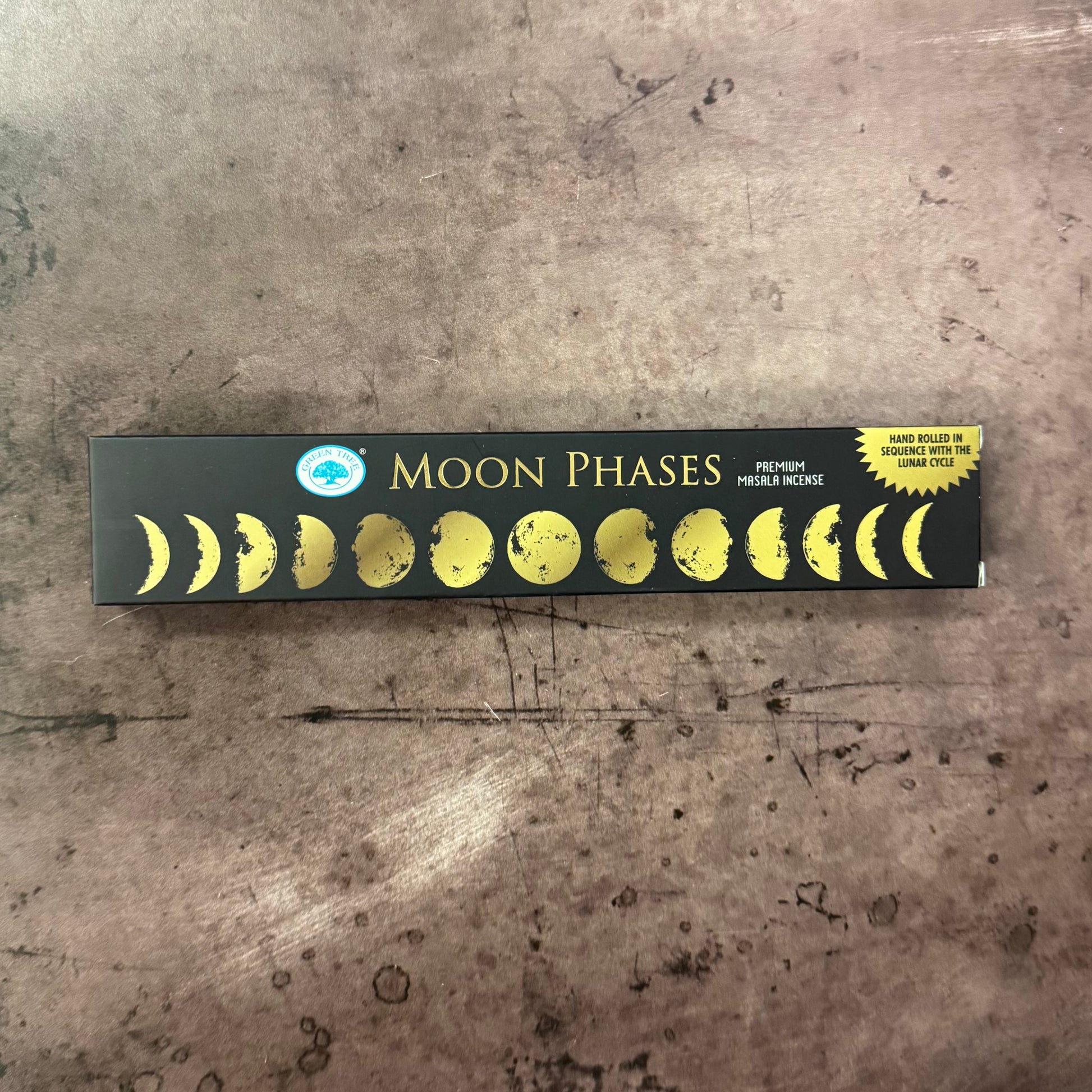 Box of incense sticks with moon phases design on a textured surface