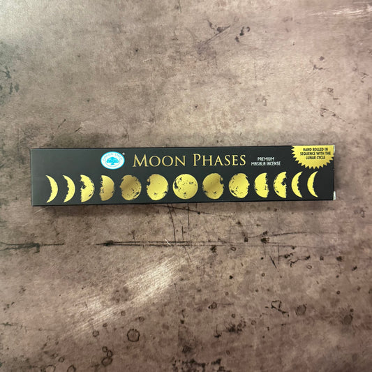 Box of incense sticks with moon phases design on a textured surface