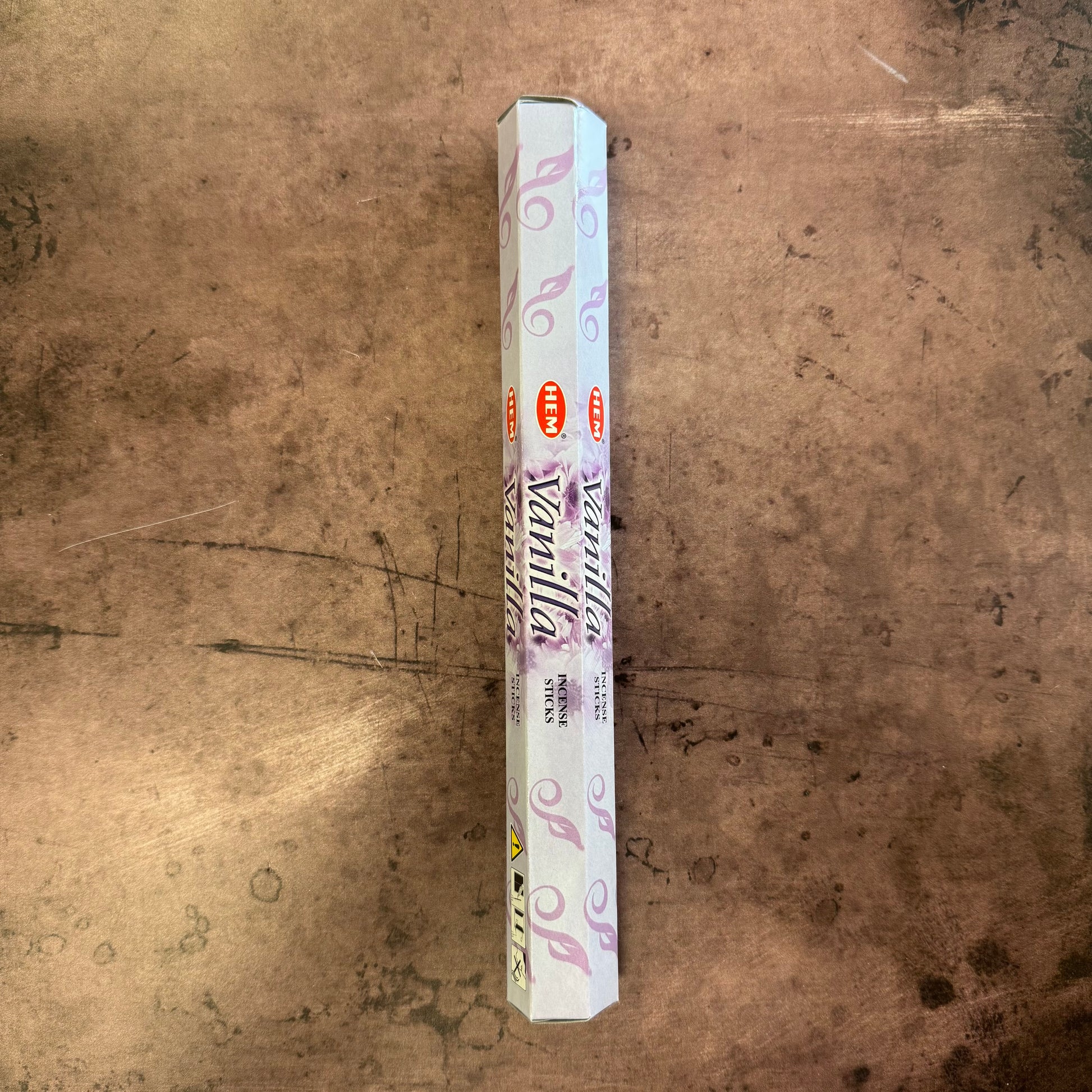 Vanilla-scented incense stick box on a textured brown surface