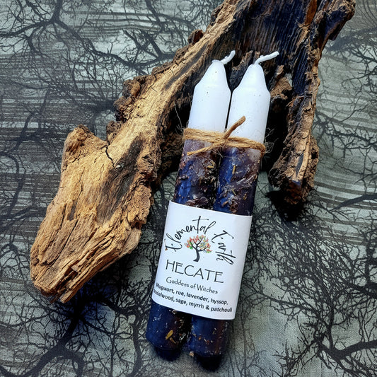 Two candles tied together with a label on a rustic wooden surface