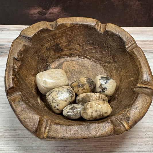 Wooden bowl with stones on a wooden surface