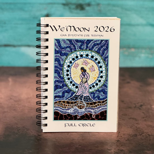 W'e'Moon 2026 calendar with artistic design on a wooden surface