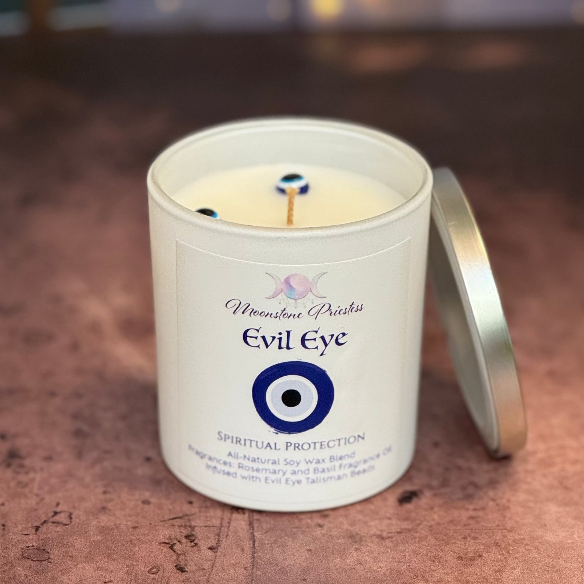 Candle in a white container with 'Evil Eye' label on a textured surface