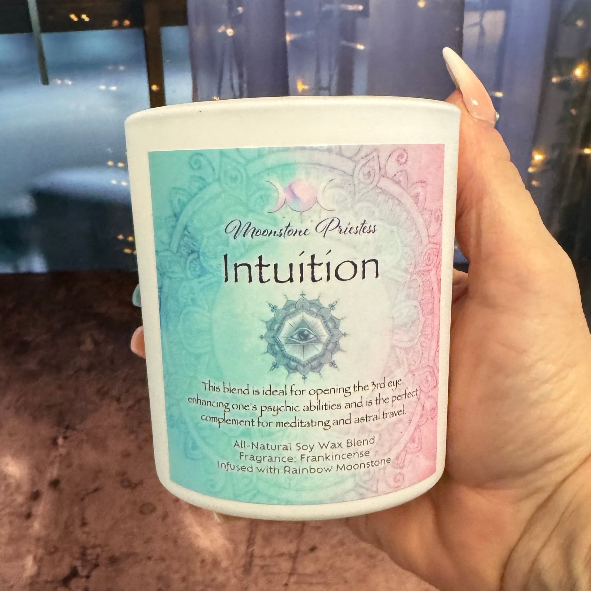 Candle labeled 'Intuition' held by a hand with a blurred background