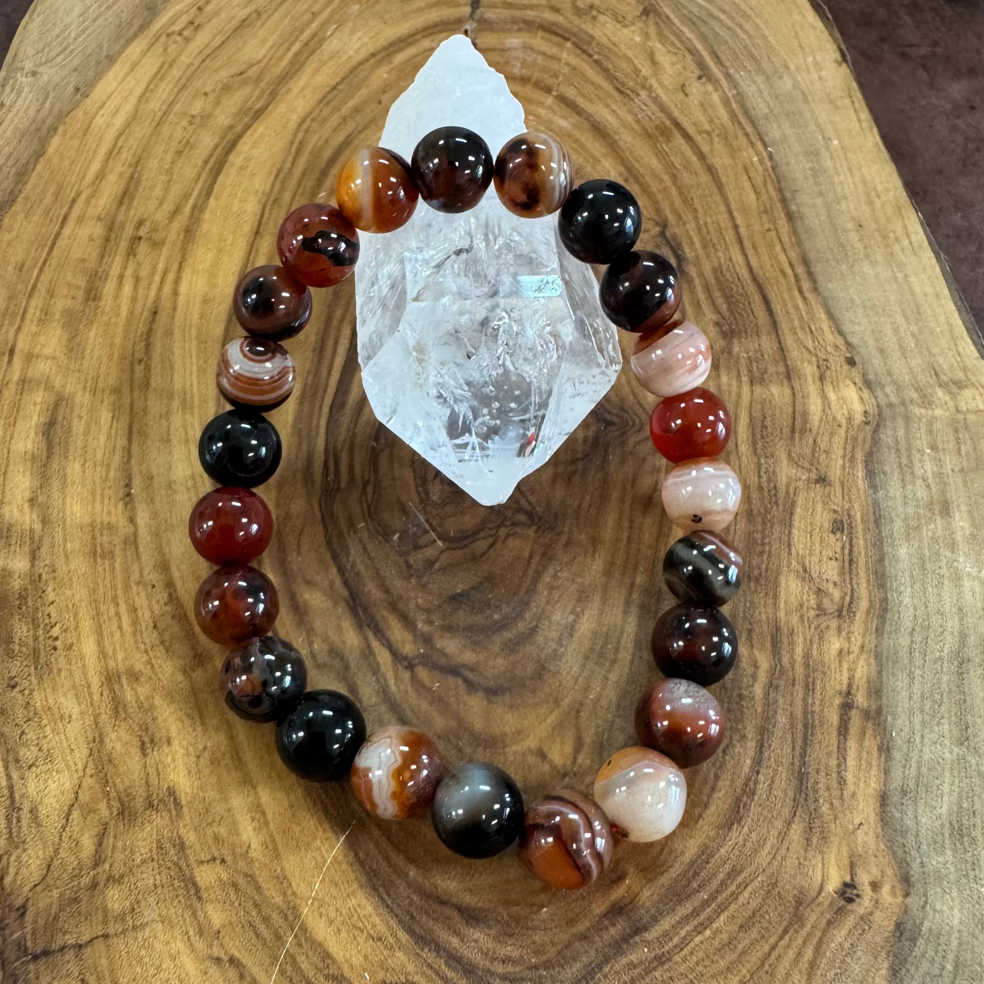 Multicolored beaded bracelet on a wooden surface with a crystal