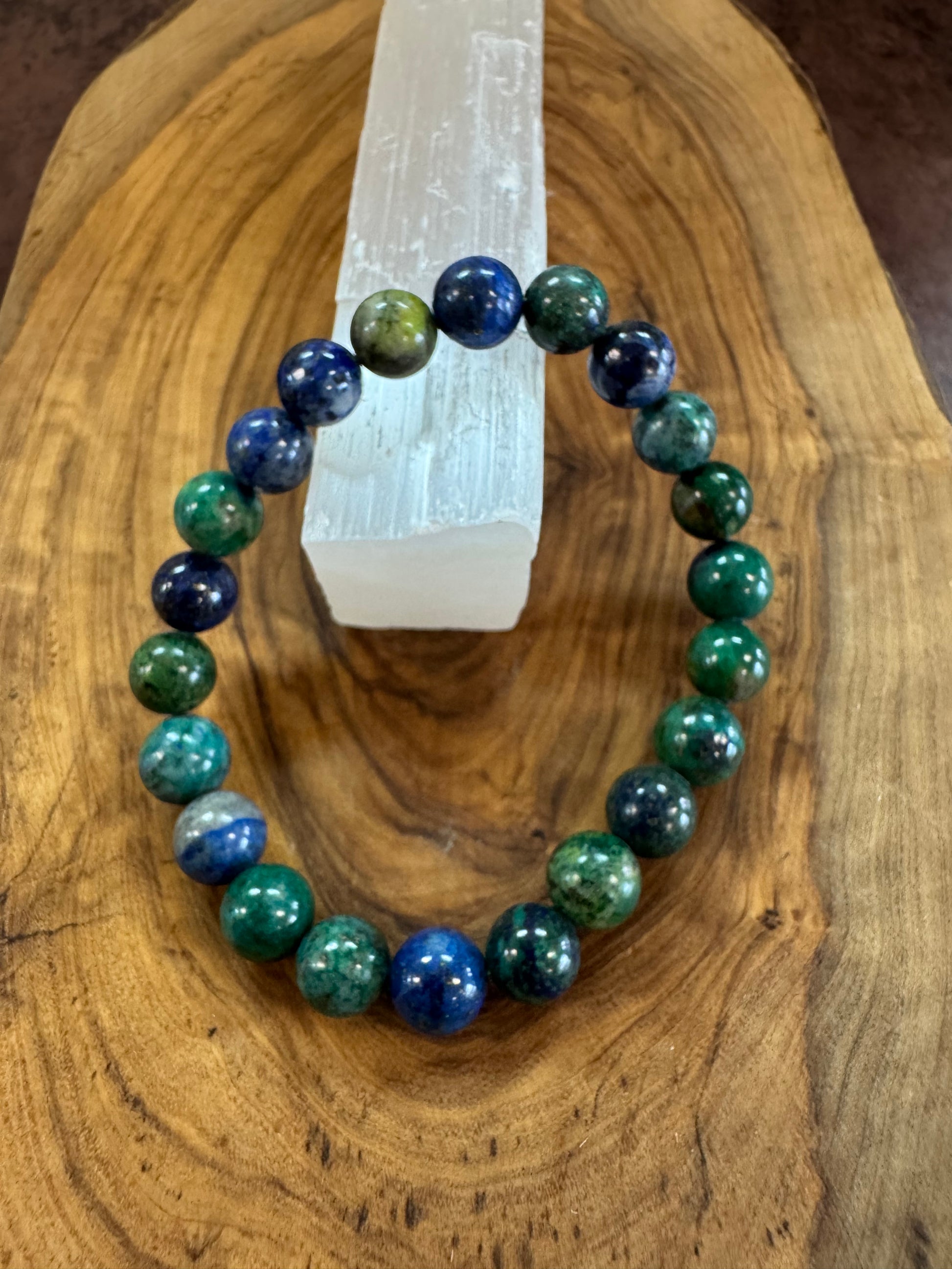 Glowing bracelet with blue and green beads on a wooden surface