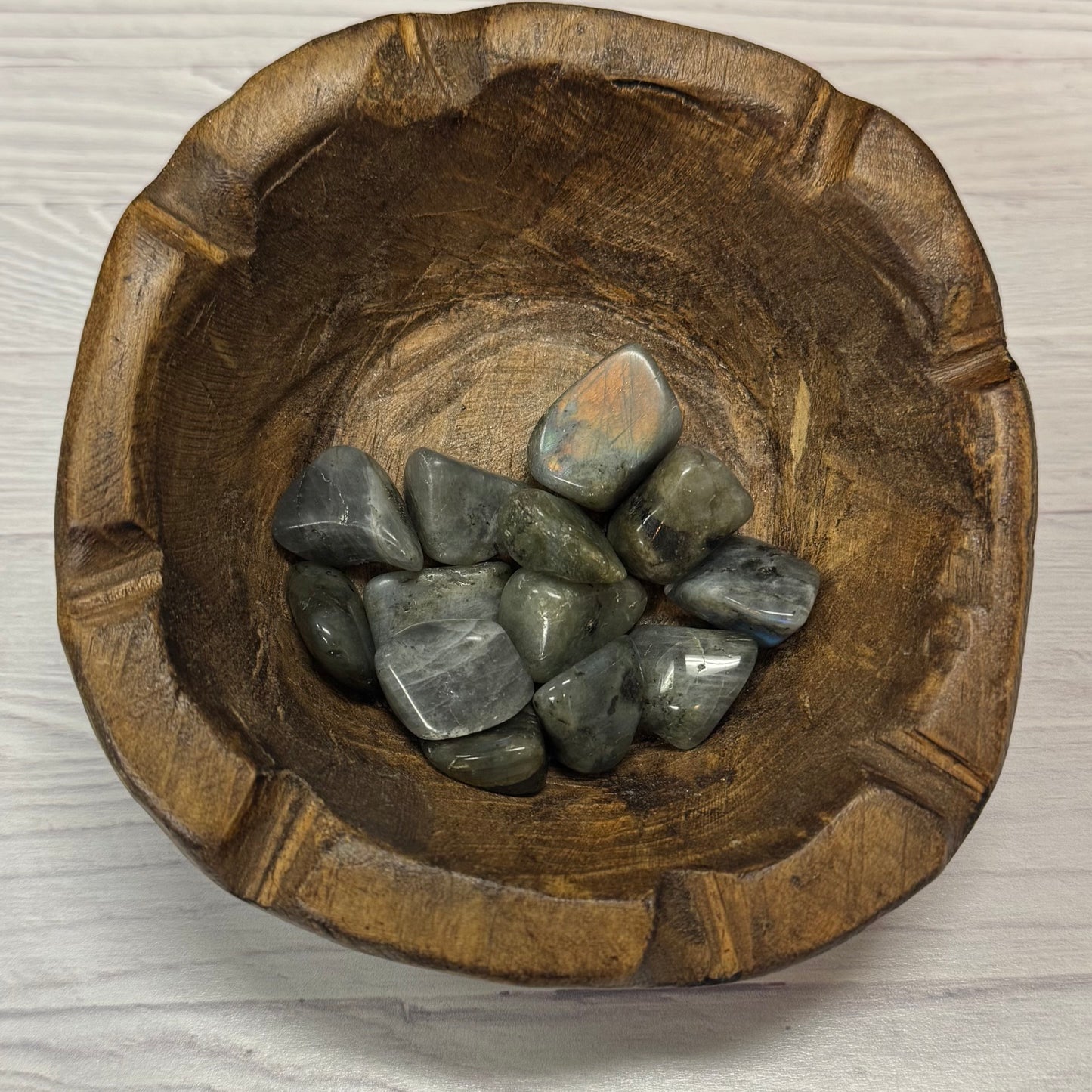 Wooden bowl with stones on a light wooden surface