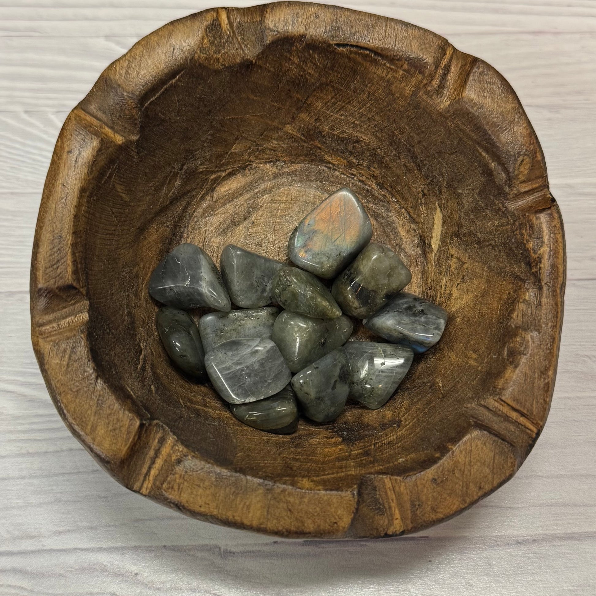 Wooden bowl with stones on a light wooden surface