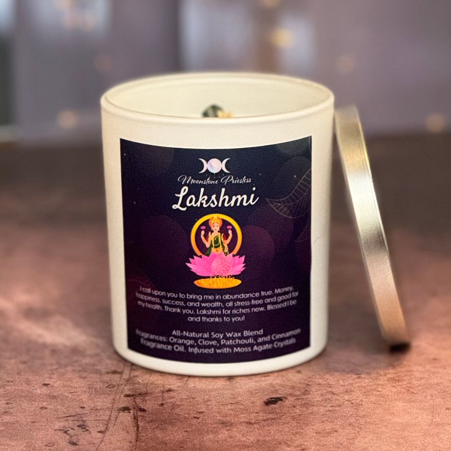 Candle with 'Lakshmi' label on a wooden surface