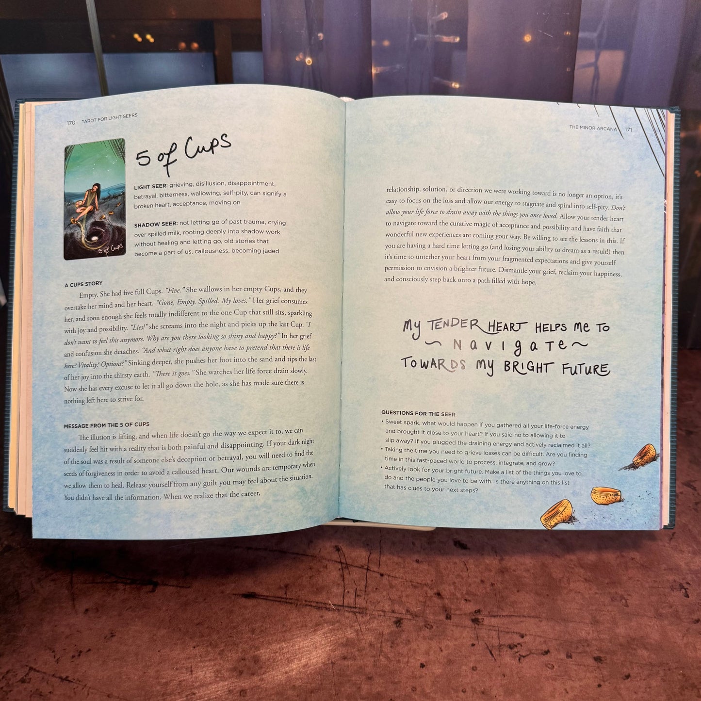 Open book with text and a small illustration on a wooden surface