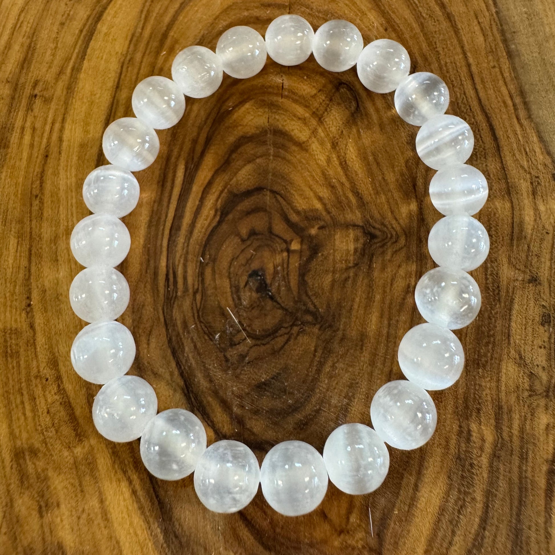 White beaded bracelet on a wooden surface