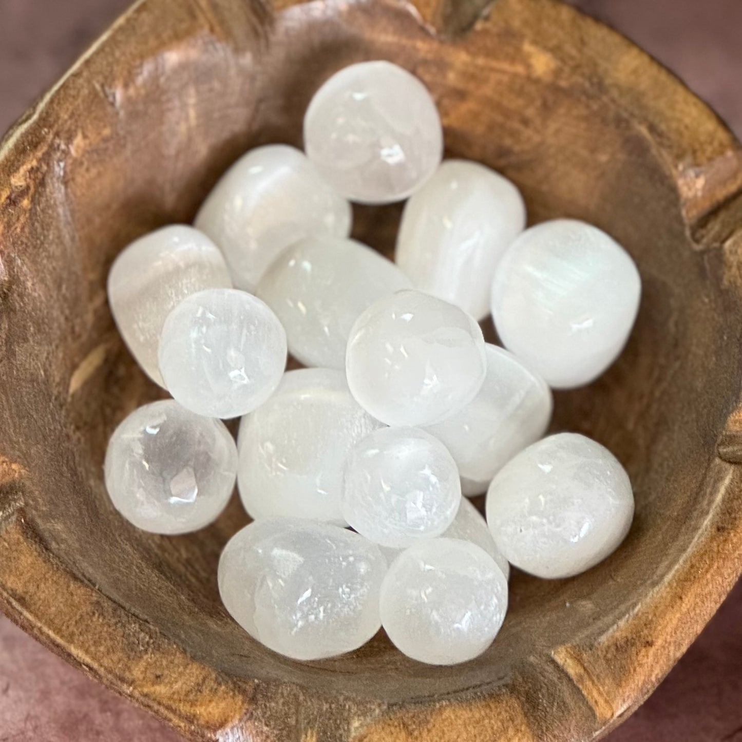 White selenite pocket stone in a wooden bowl