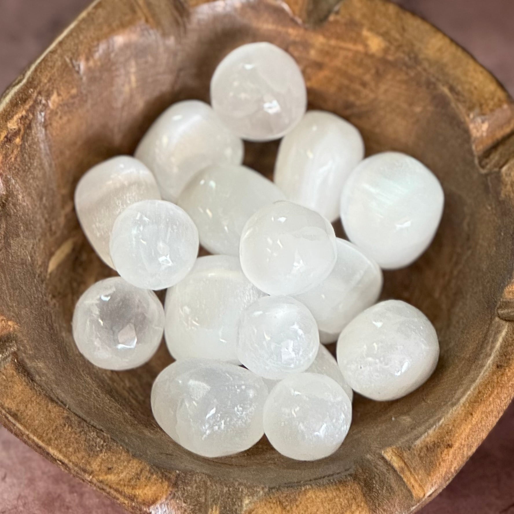 White selenite pocket stone in a wooden bowl