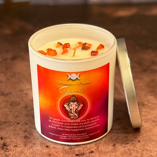Candle in a white container with a red label featuring an illustration of Ganesha on a wooden surface.