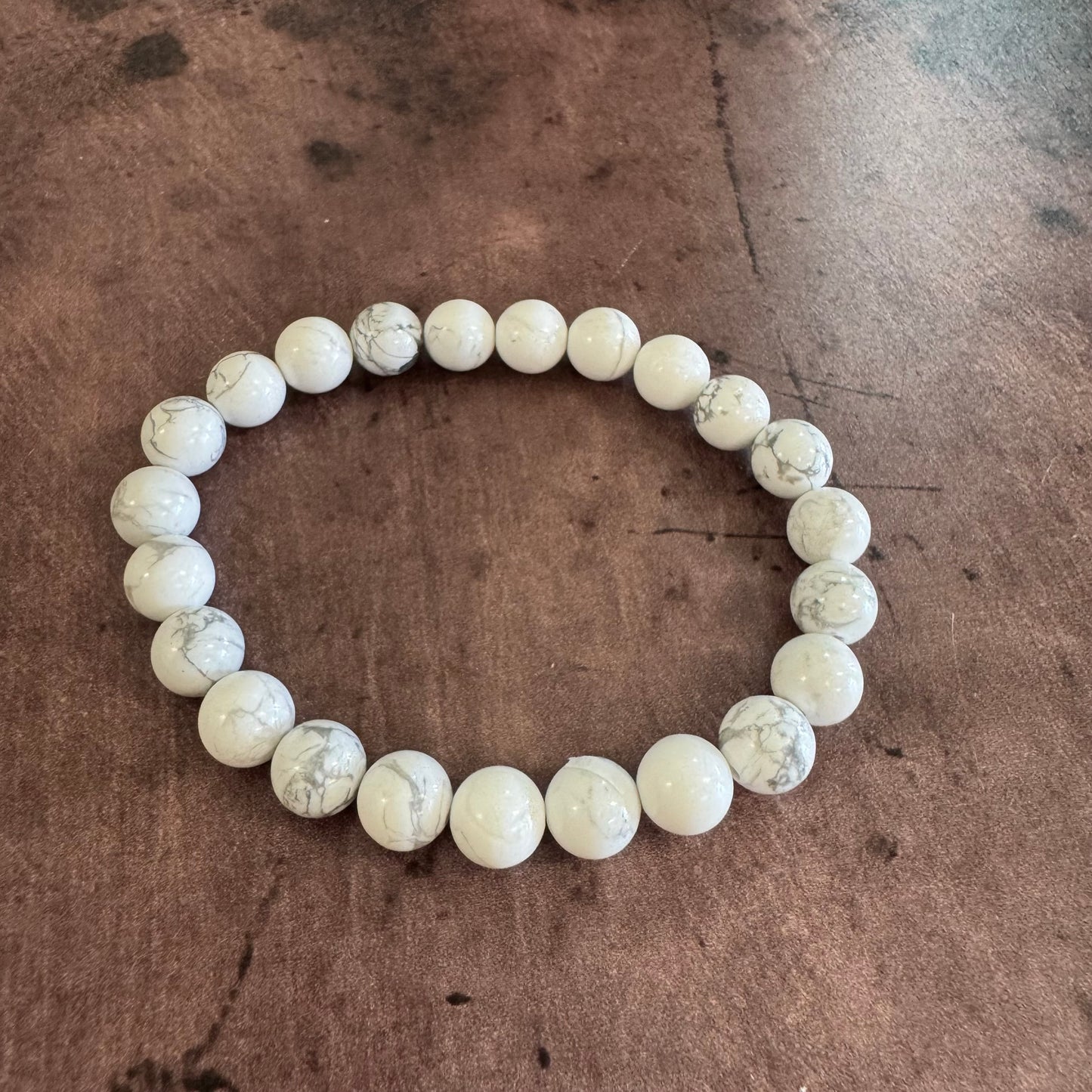 White beaded bracelet on a brown surface