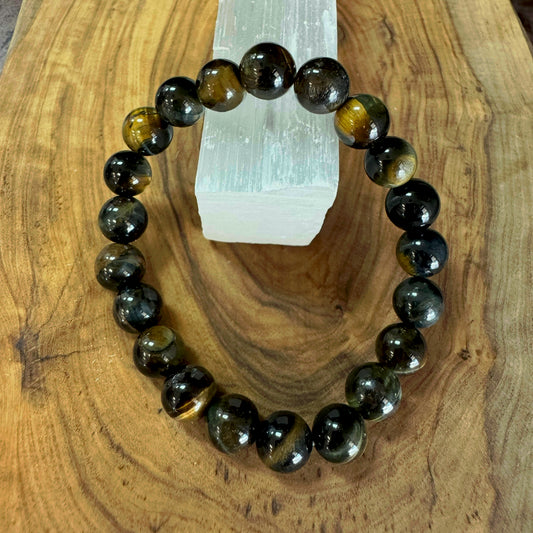 Beaded bracelet with blue tiger's eye stones on a wooden surface