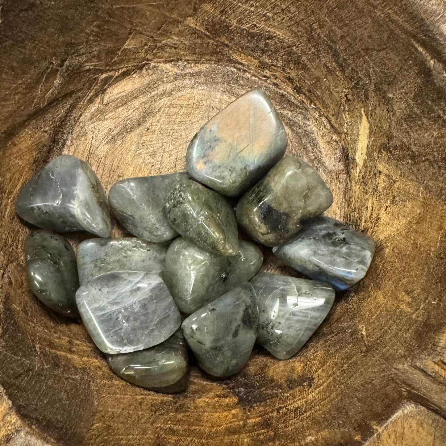 Collection of gray stones in a wooden bowl