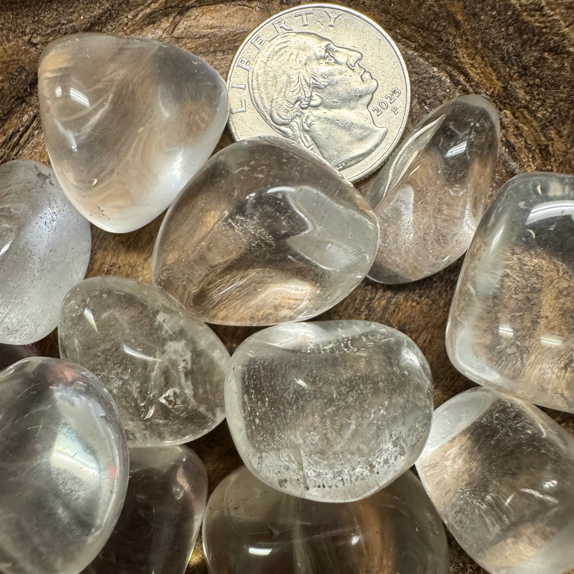 Clear crystals on a wooden surface with a quarter for scale