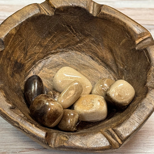 Wooden bowl with stones on a wooden surface