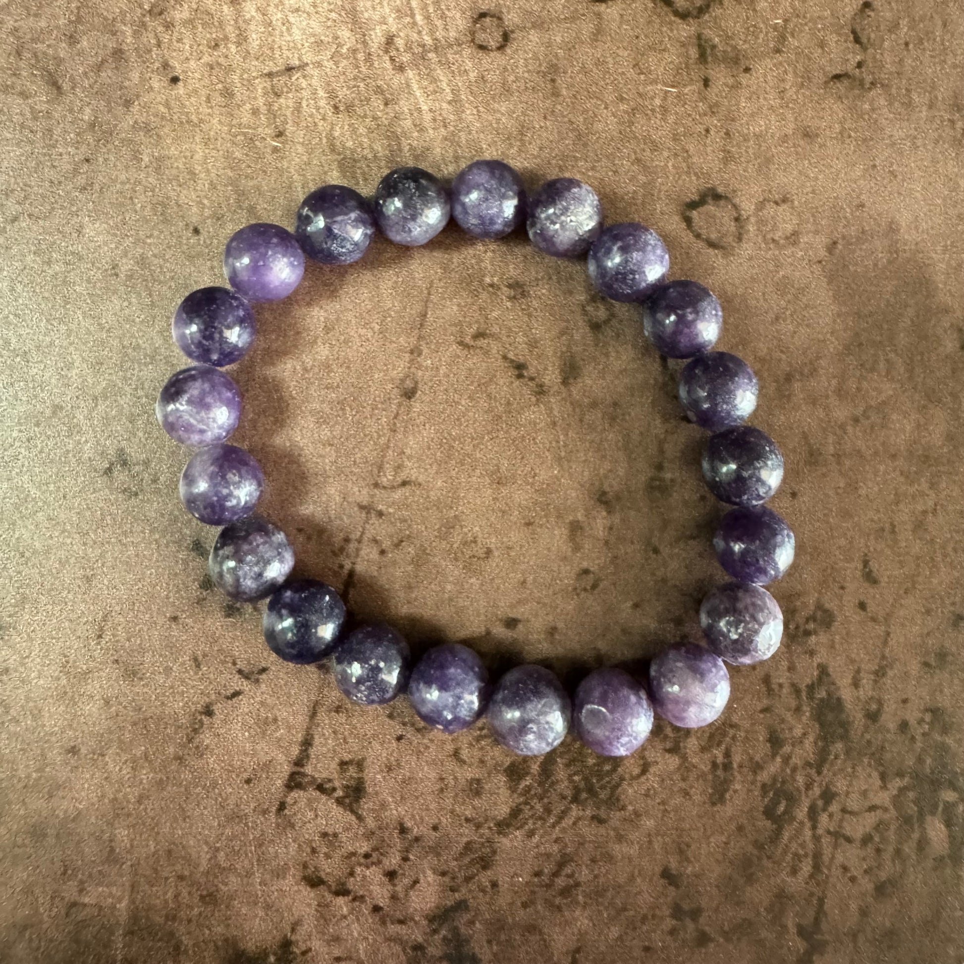 Purple beaded bracelet on a textured brown surface