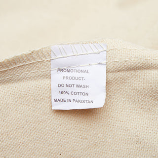 Sewn-in fabric content and care label inside the natural cotton canvas tote bag.