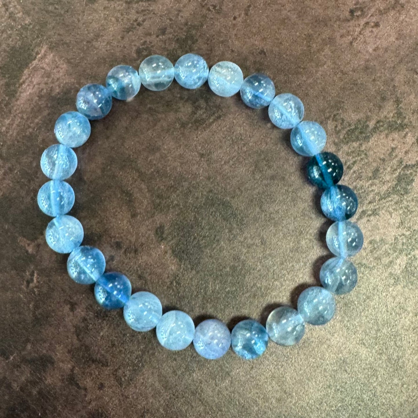 Blue beaded bracelet on a textured surface