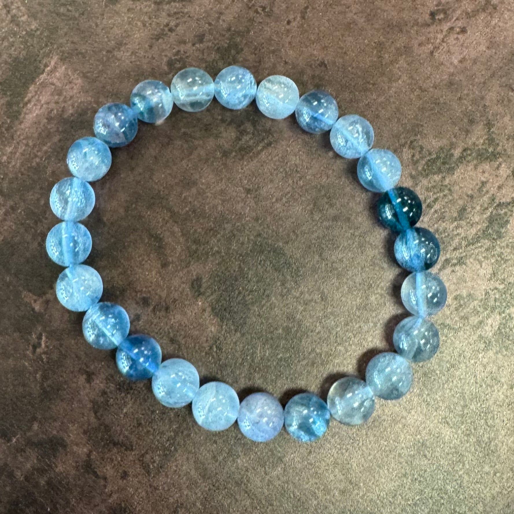 Blue beaded bracelet on a textured surface