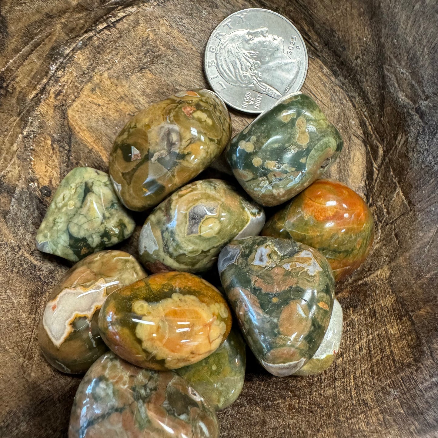 Marbled stones with a quarter for scale on a wooden surface