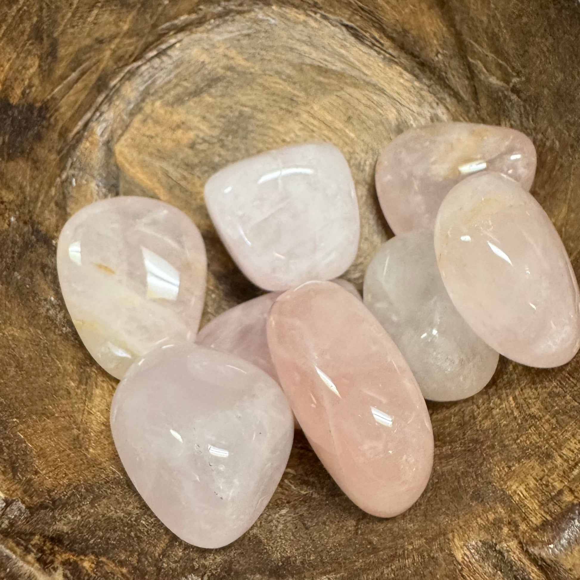Set of rose quartz stones on a wooden surface