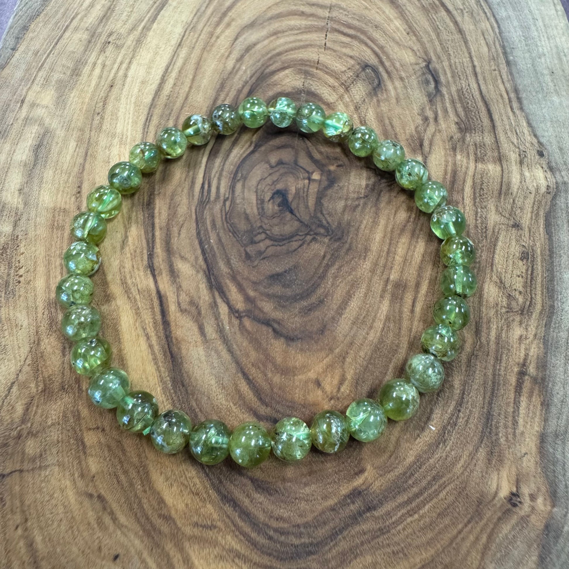 Green beaded bracelet on a wooden surface