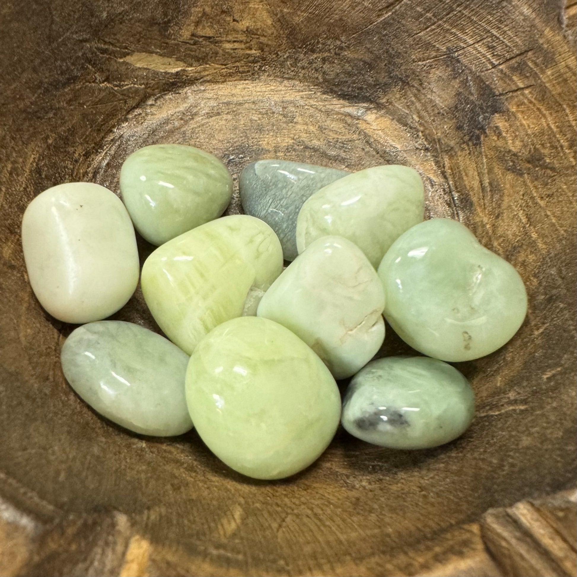 Green stones on a wooden surface