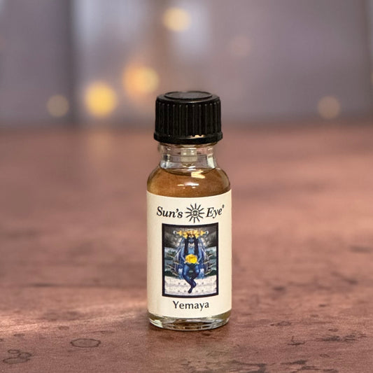 Bottle of Sun's Eye Yemaya oil on a wooden surface with a blurred background