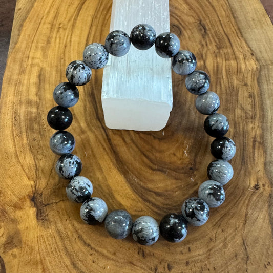 Black and gray beaded bracelet on a wooden surface