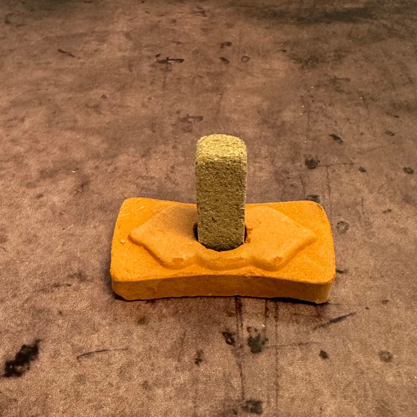 Yellow concrete float tool with a textured surface on a concrete floor.