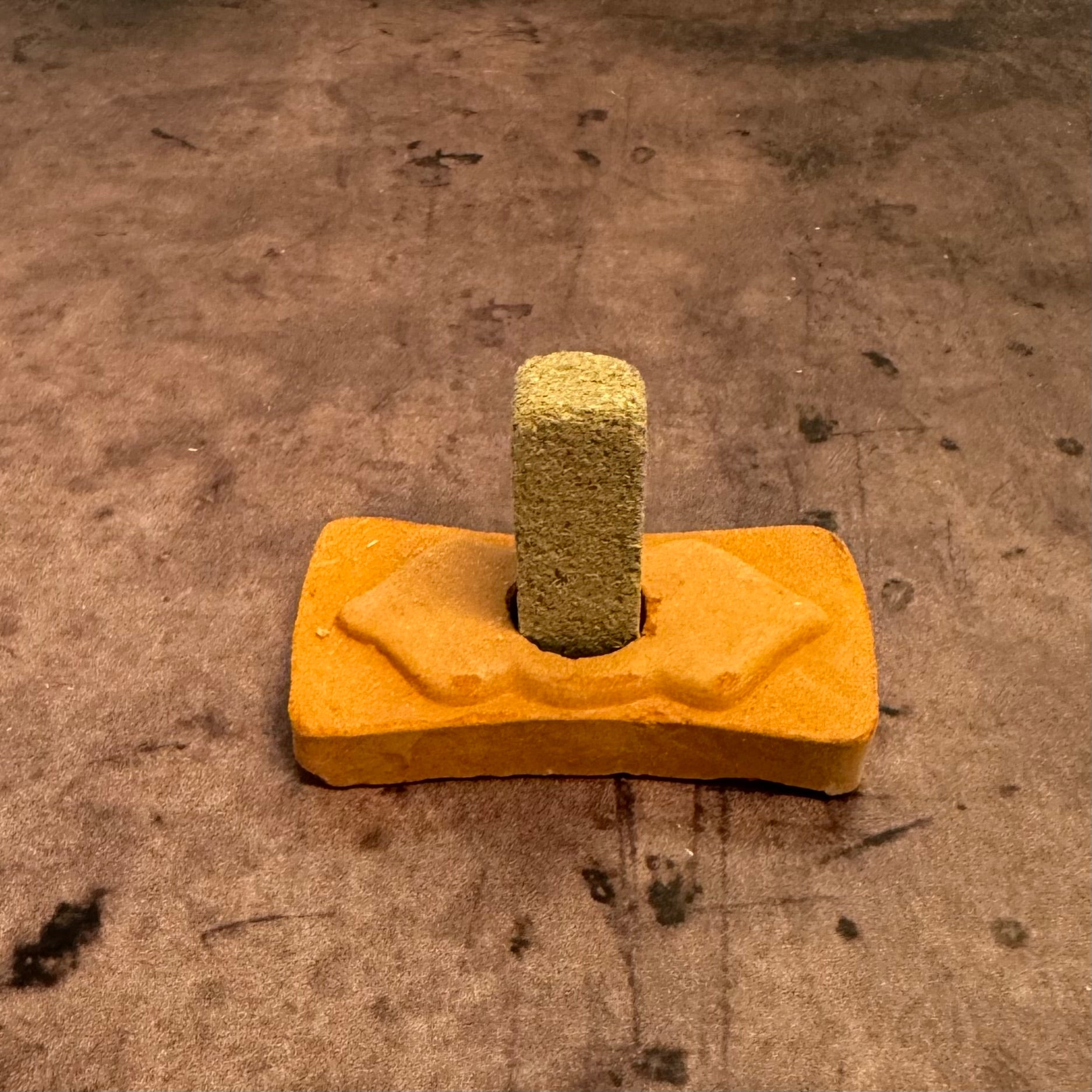 Yellow concrete float tool with a textured surface on a concrete floor.