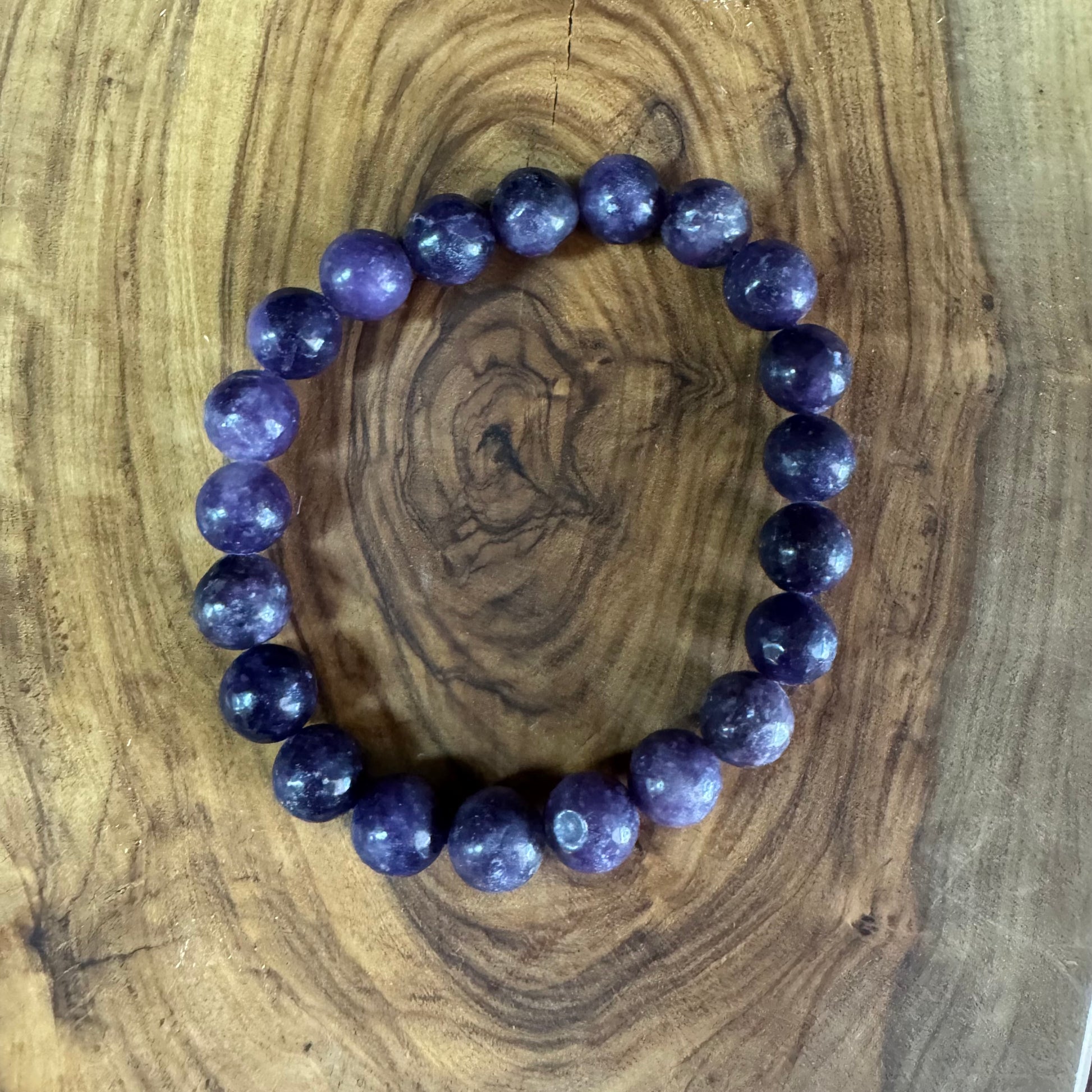 Purple beaded bracelet on a wooden surface