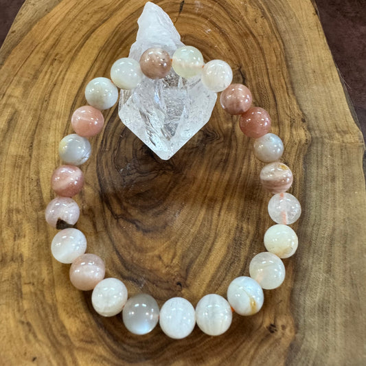 Beaded bracelet with pink and white stones on a wooden surface
