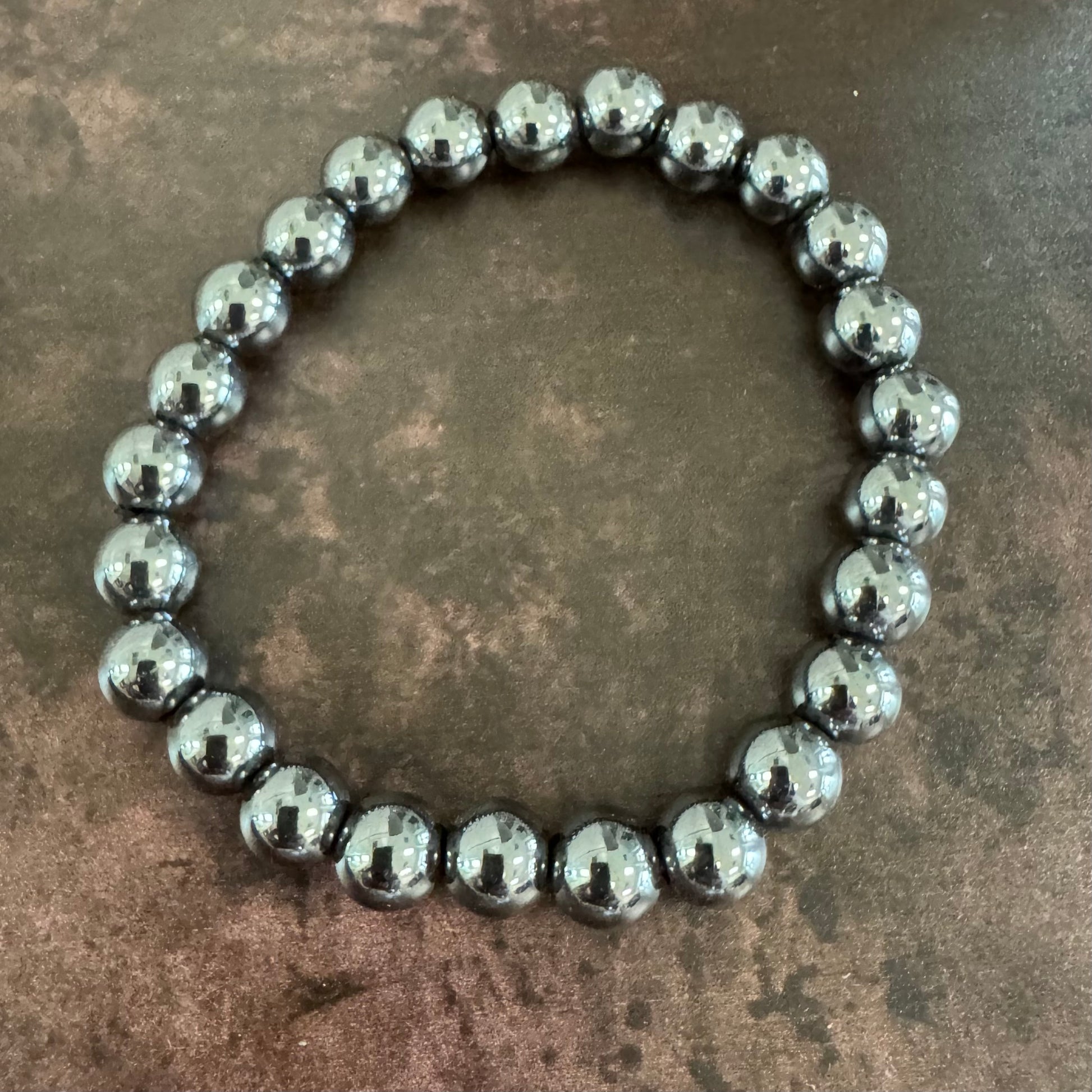 Silver beaded bracelet on a textured brown surface