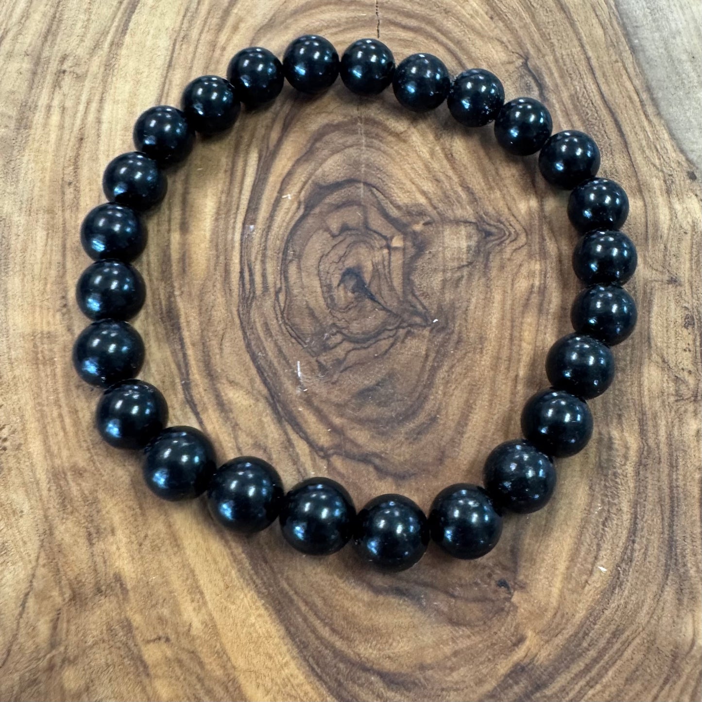 Black beaded bracelet on a wooden surface