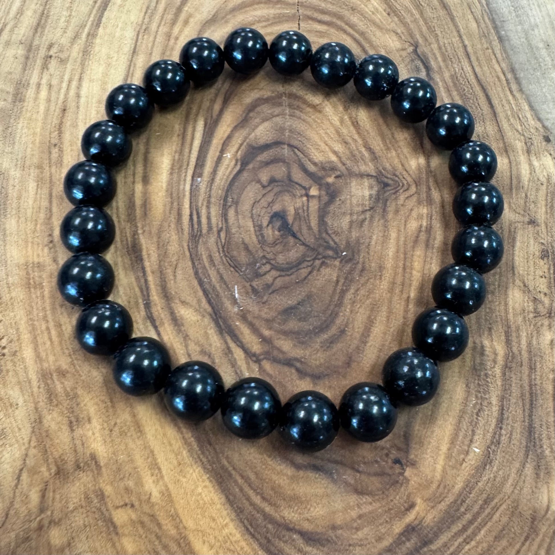 Black beaded bracelet on a wooden surface