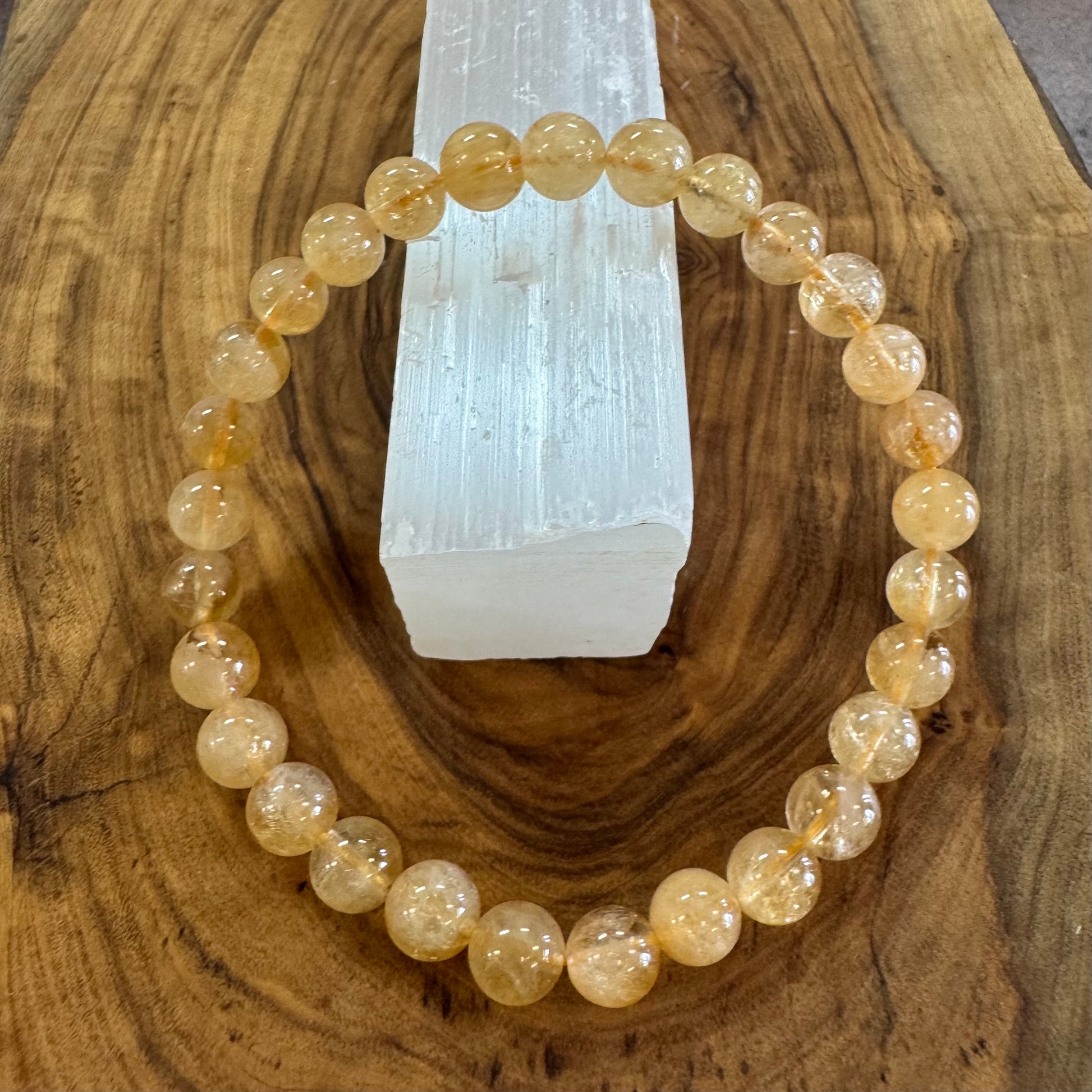 Beaded bracelet on a wooden surface with a crystal in the background