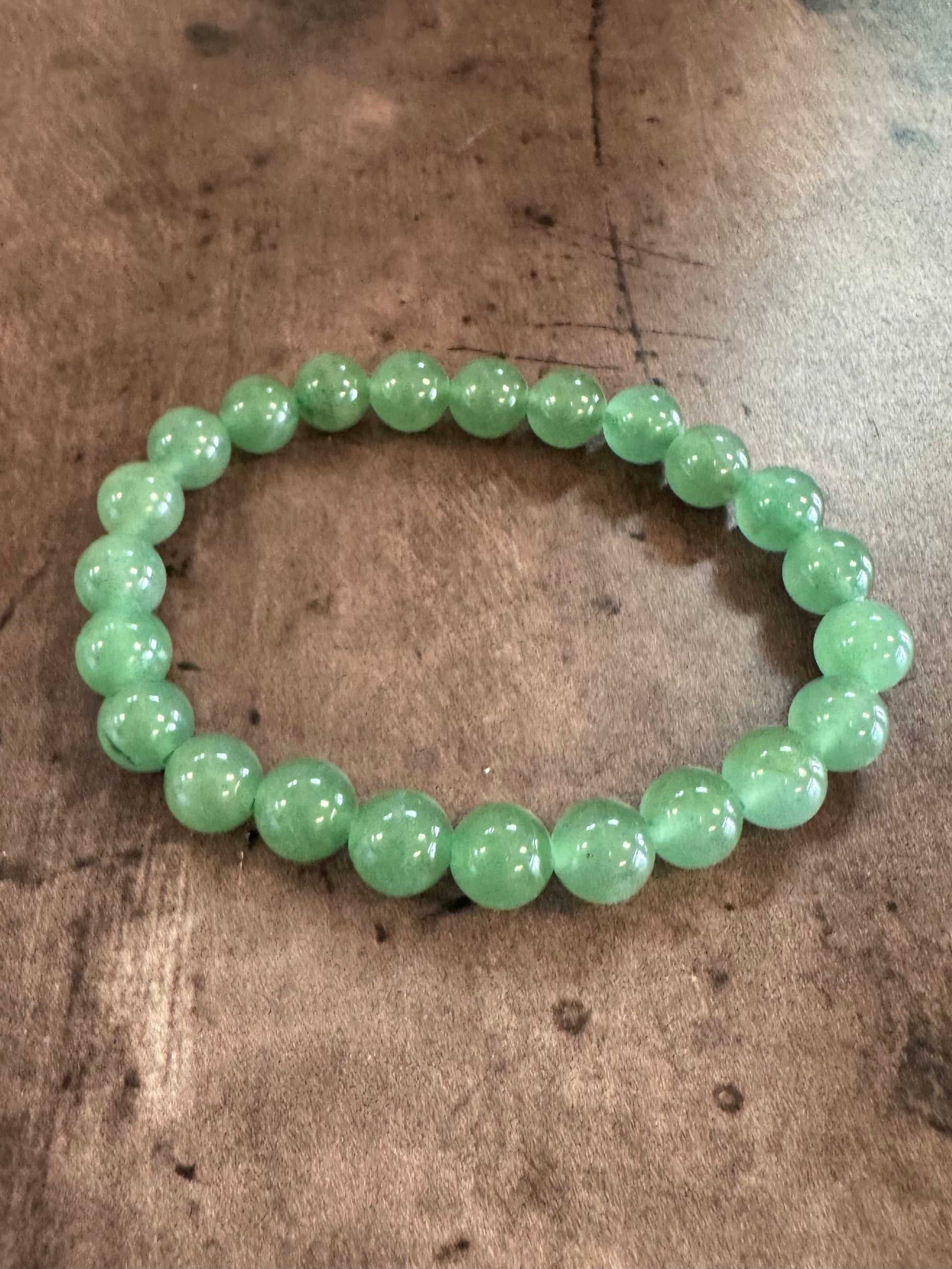 Green beaded bracelet on a wooden surface
