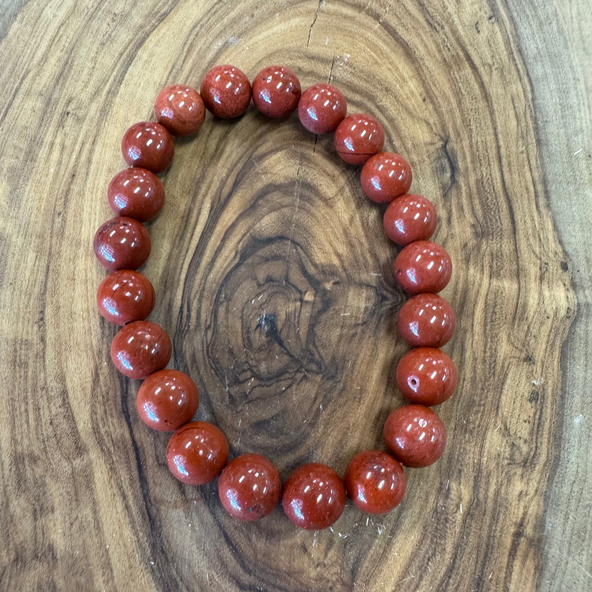 Red beaded bracelet on a wooden surface