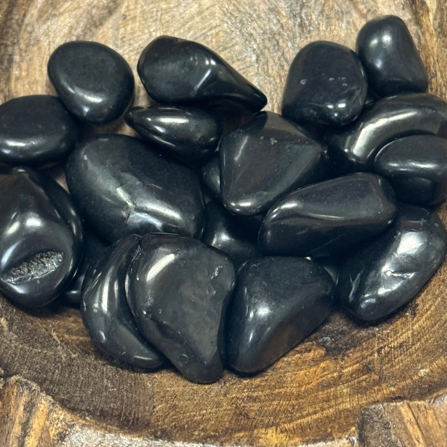 Collection of black stones on a wooden surface