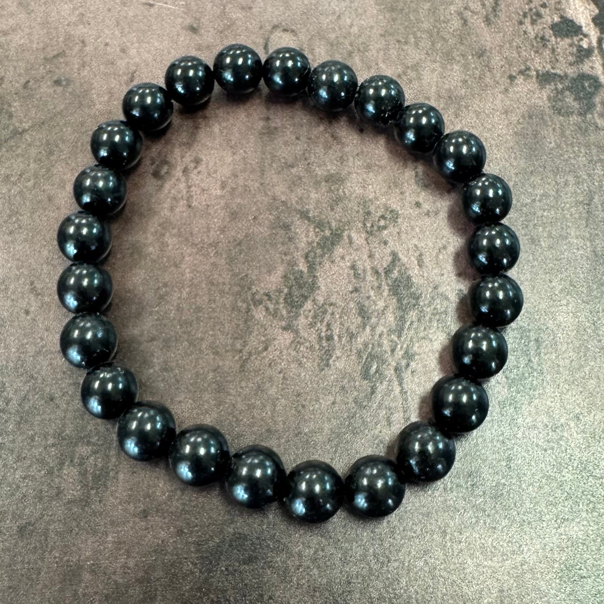 Black beaded bracelet on a textured surface