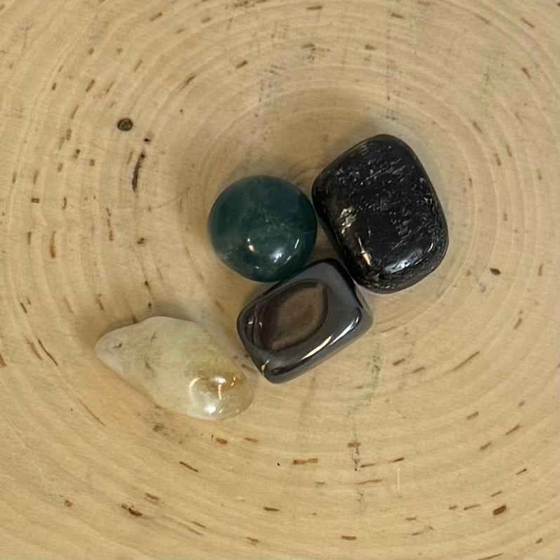 Three stones of different colors on a woven surface
