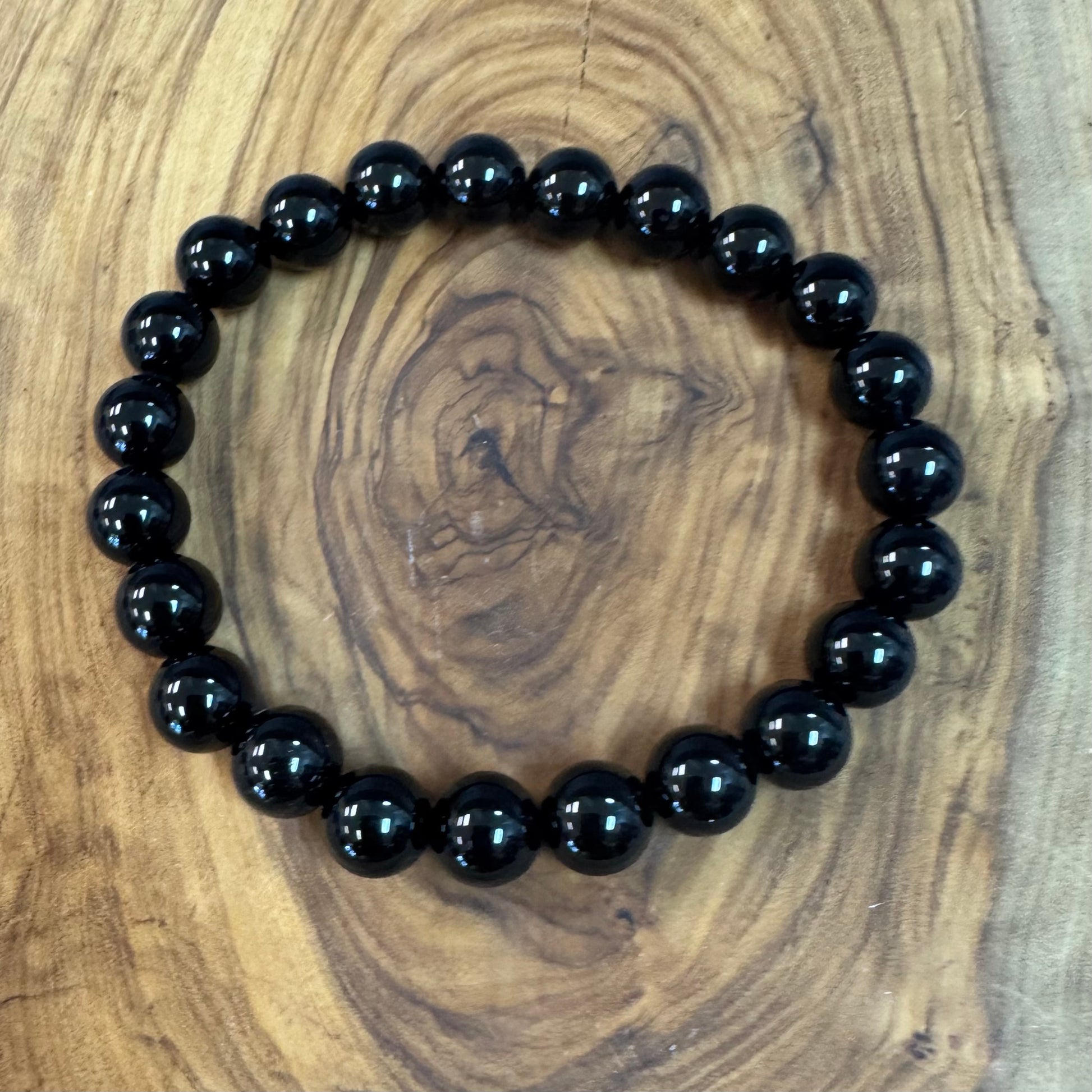 Black beaded bracelet on a wooden surface