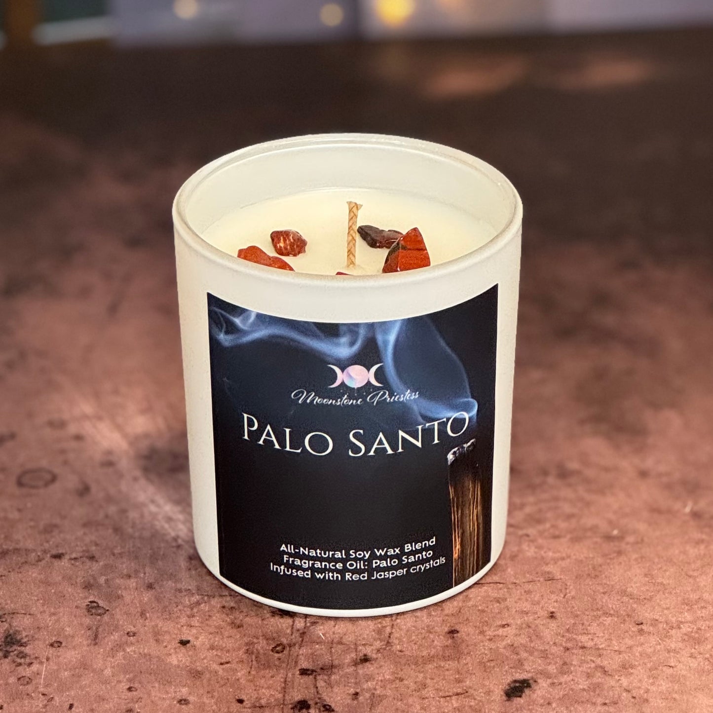 Palo Santo candle in a white container with a label on a textured surface