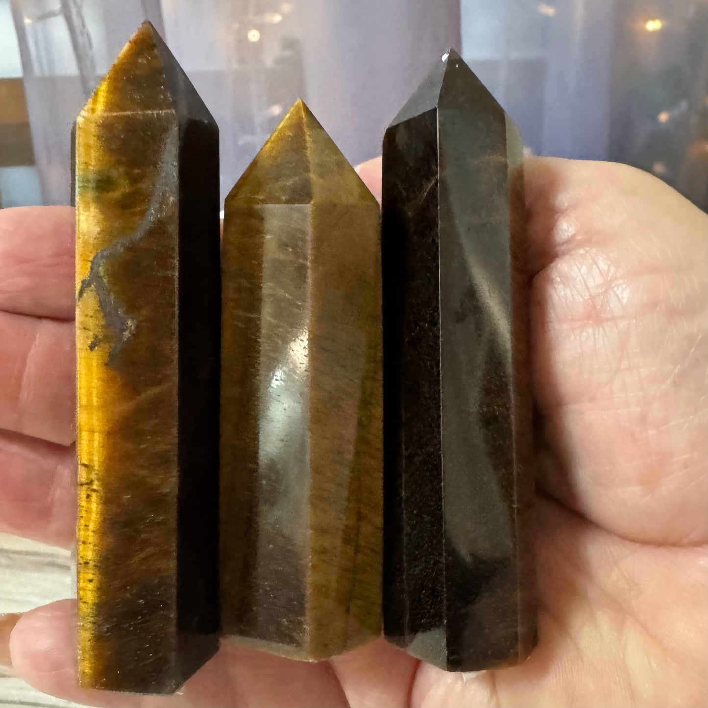 Three crystal points held in a hand with a blurred background