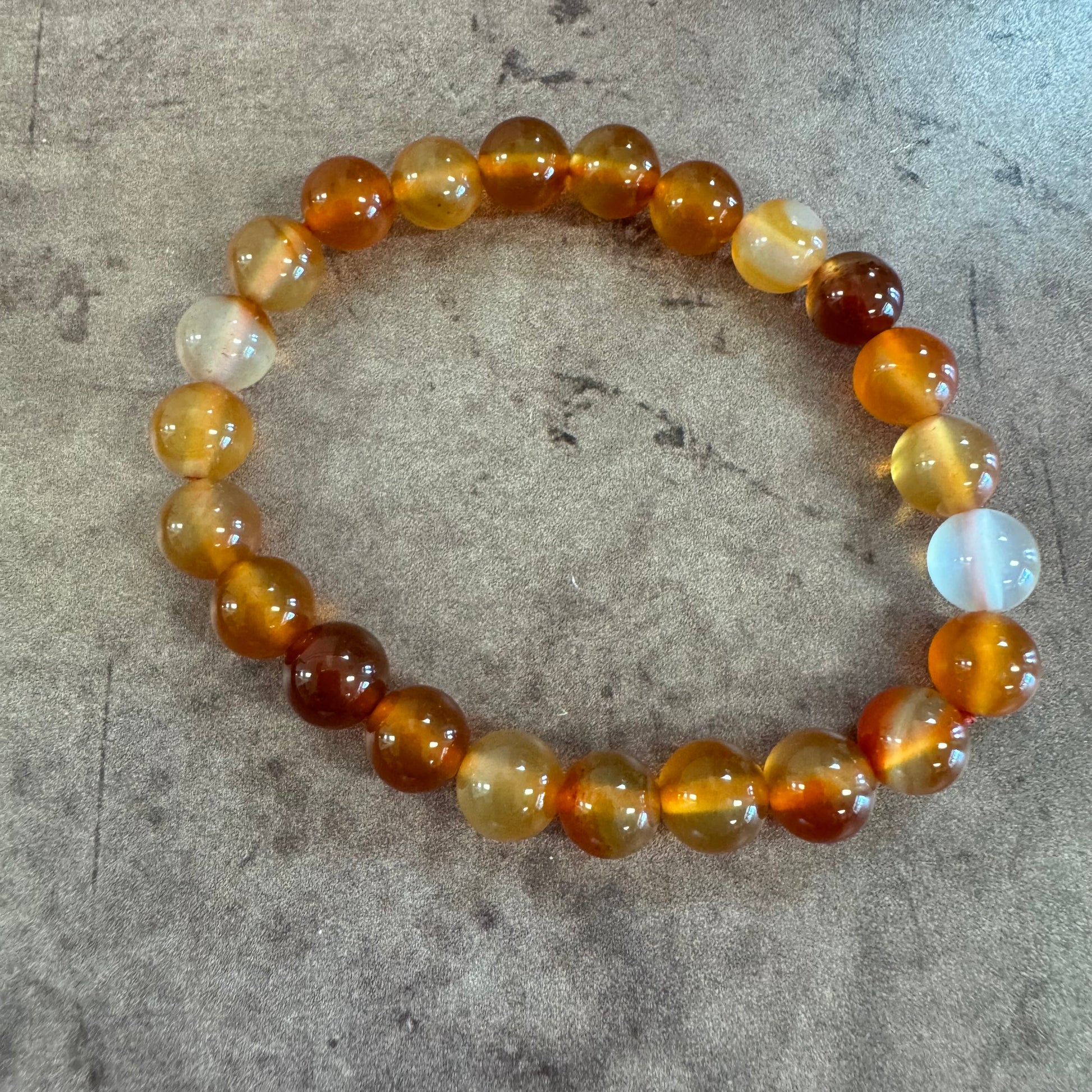 Beaded bracelet with multicolored beads on a gray surface
